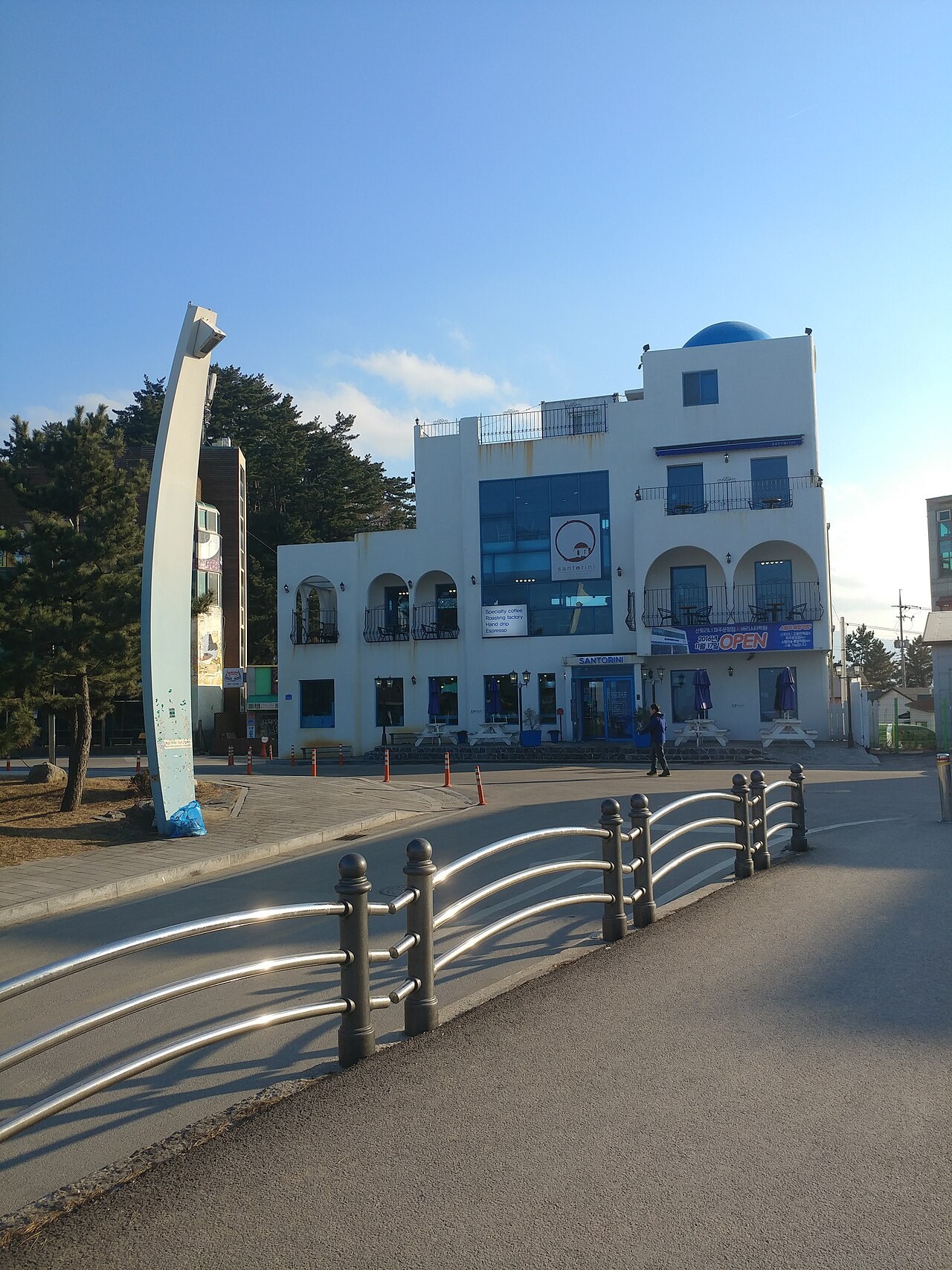 A white Santorini-style specialty-coffee café on the Anmok seafront, Gangneung