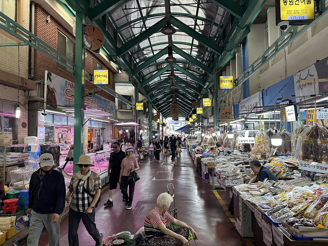 The covered arcade of Gangneung Jungang Market with food stalls and shoppers