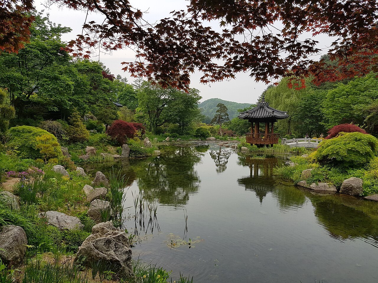 A hanok pavilion reflected in a still pond at the Garden of Morning Calm, Gapyeong