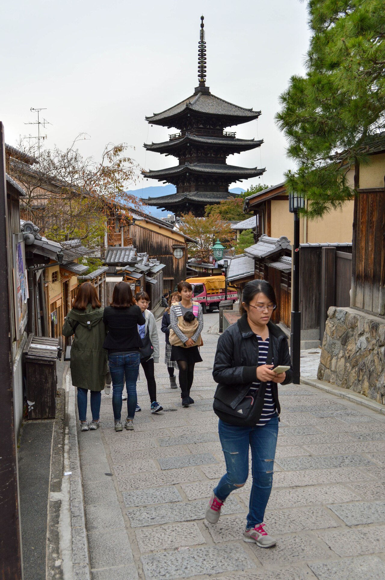 一个人走在城市街道上,专注地看着自己的智能手机