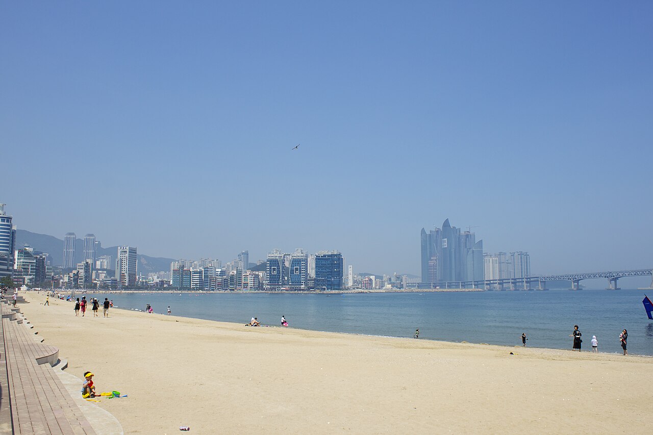白天的广安里海滩,背后是城市天际线和大桥