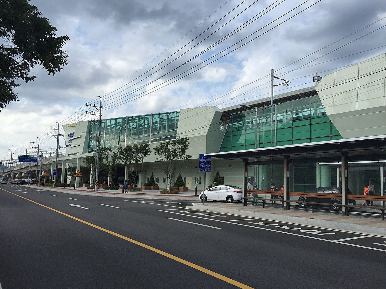 Gonjiam Station building with its green glass facade and a bus shelter on the street in front