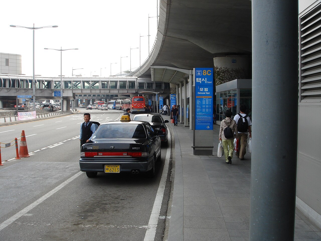 The curbside taxi rank at Incheon Airport, with a black deluxe (mobeom) taxi waiting