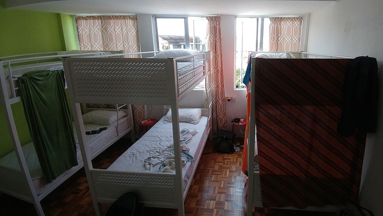 带上下铺的六人间青旅宿舍房间（经济型住宿示例；摄于马来西亚古晋，并非韩国实景）