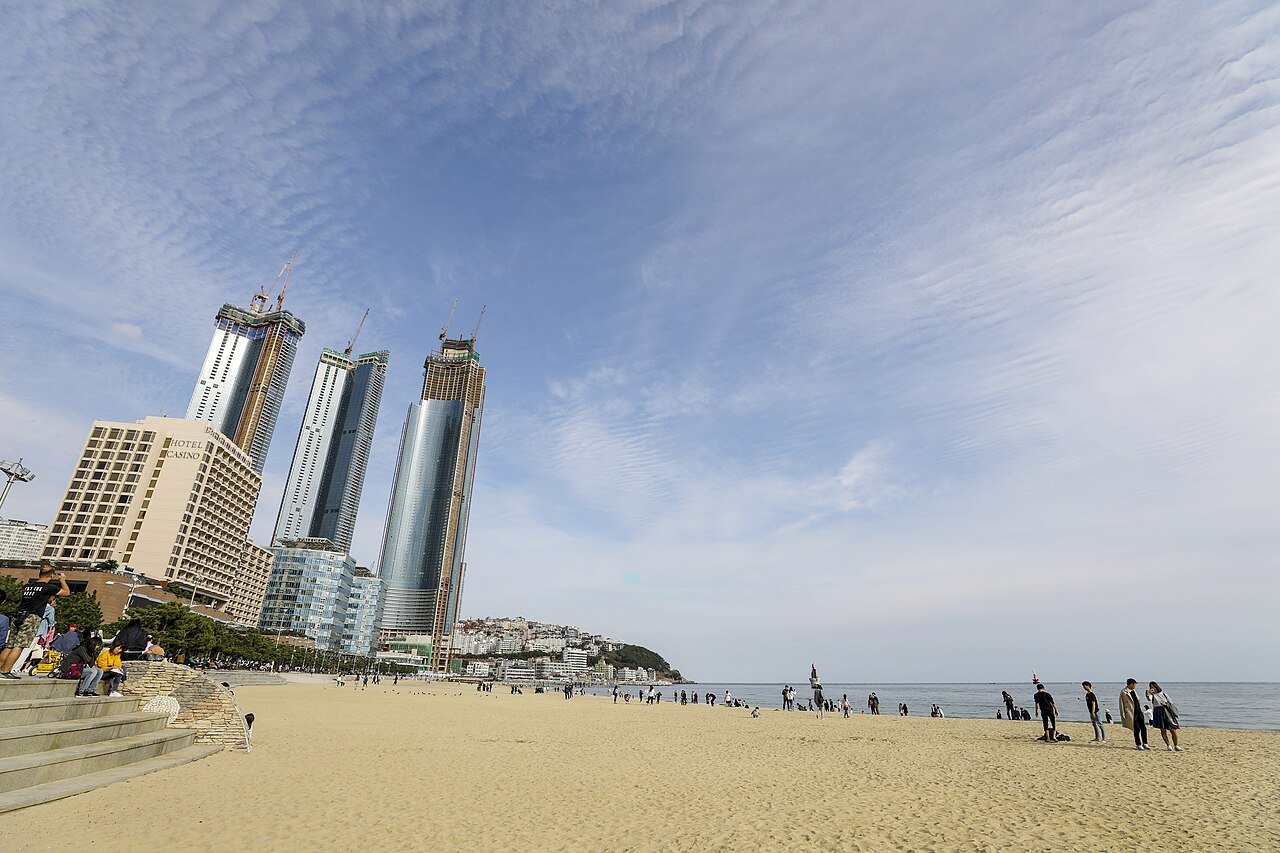 釜山海云台海滩,人潮涌动,背后是城市天际线