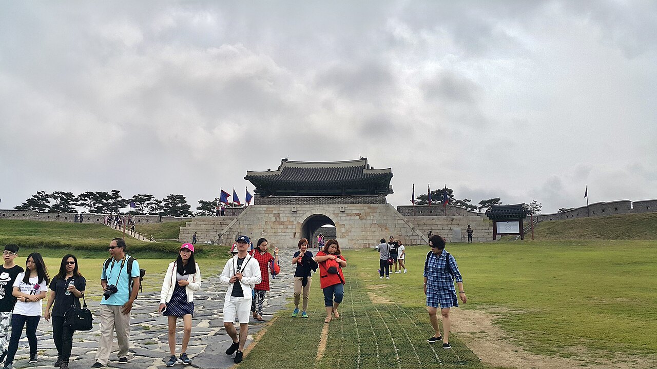 水原华城的东门苍龙门,游客在草地上行走