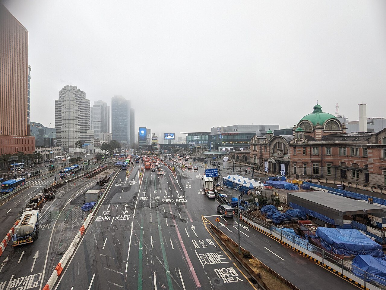 首尔站广场的开阔城市景观，旁边是现代化的 KTX 车站大楼